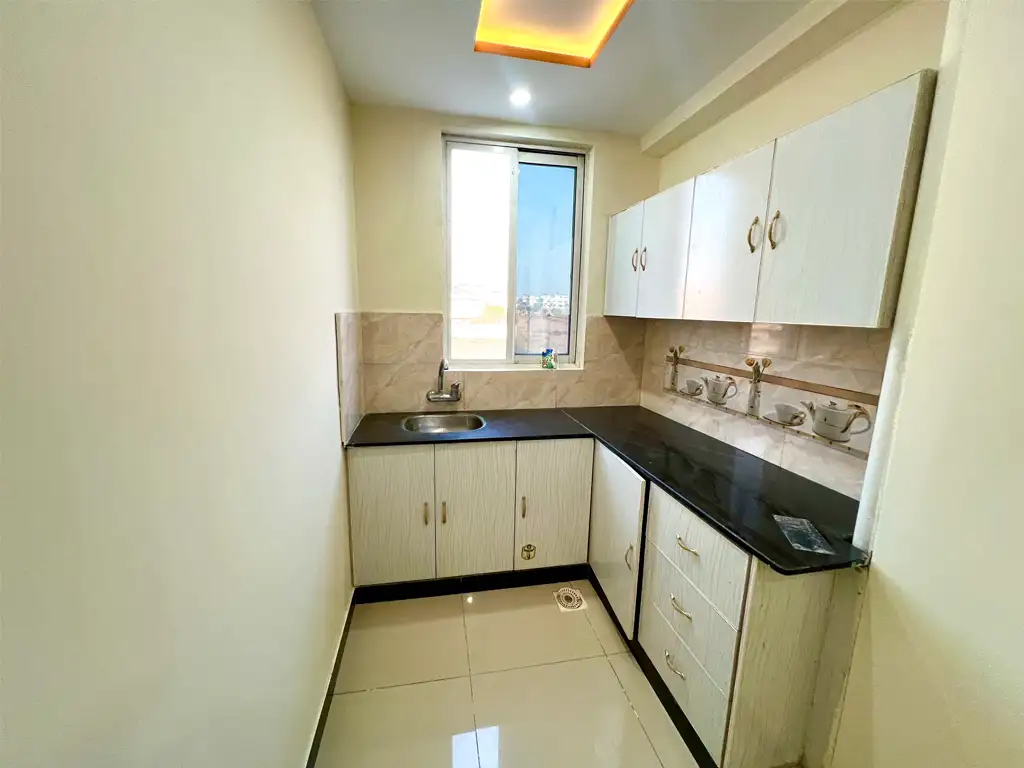 Well-lit kitchen with tiled backsplash and premium countertops – F-17 apartment for sale